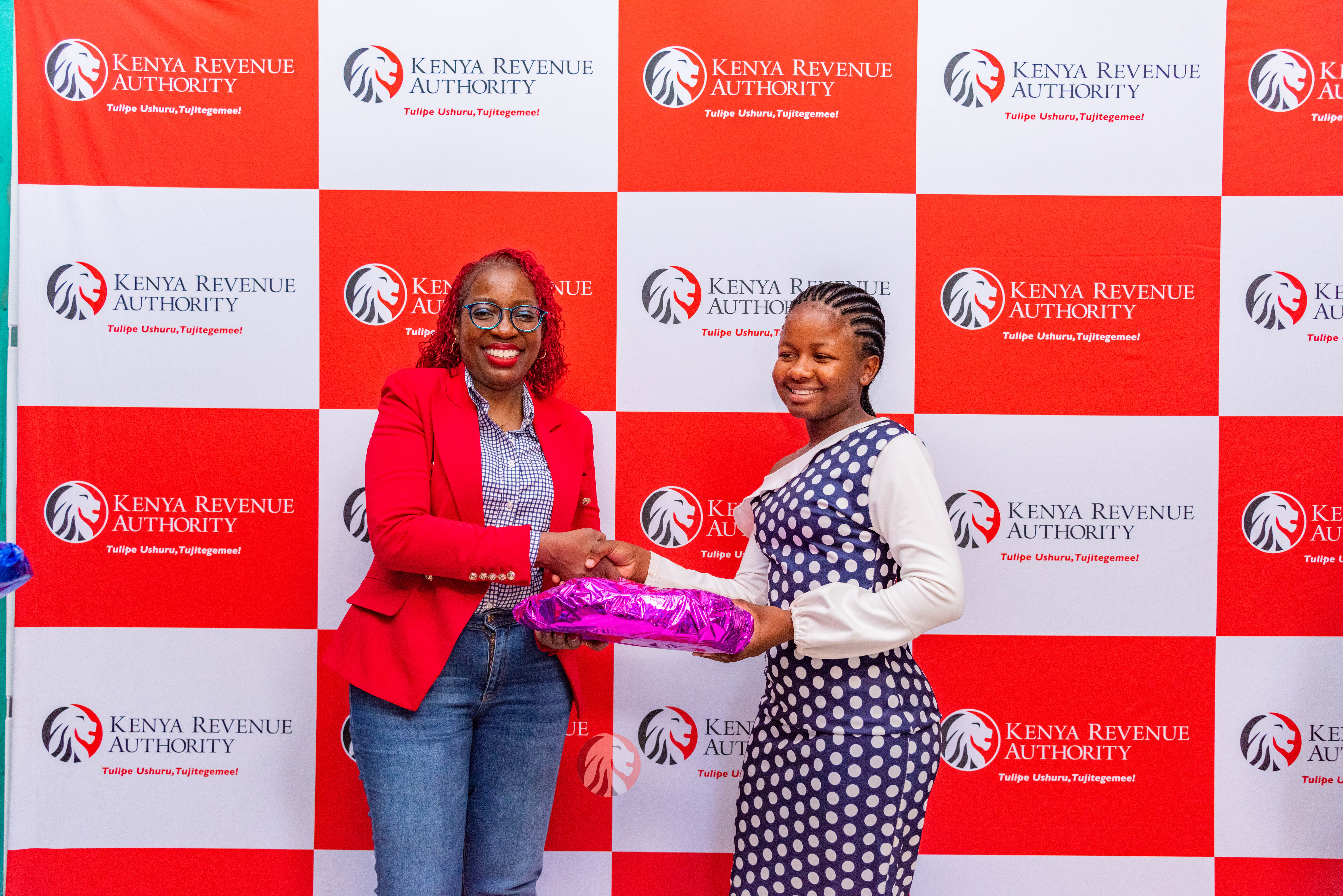 Ms. Sheila Mugusia of KRA awarding one of the beneficiaries of the Janris Foundation at the mentorship session